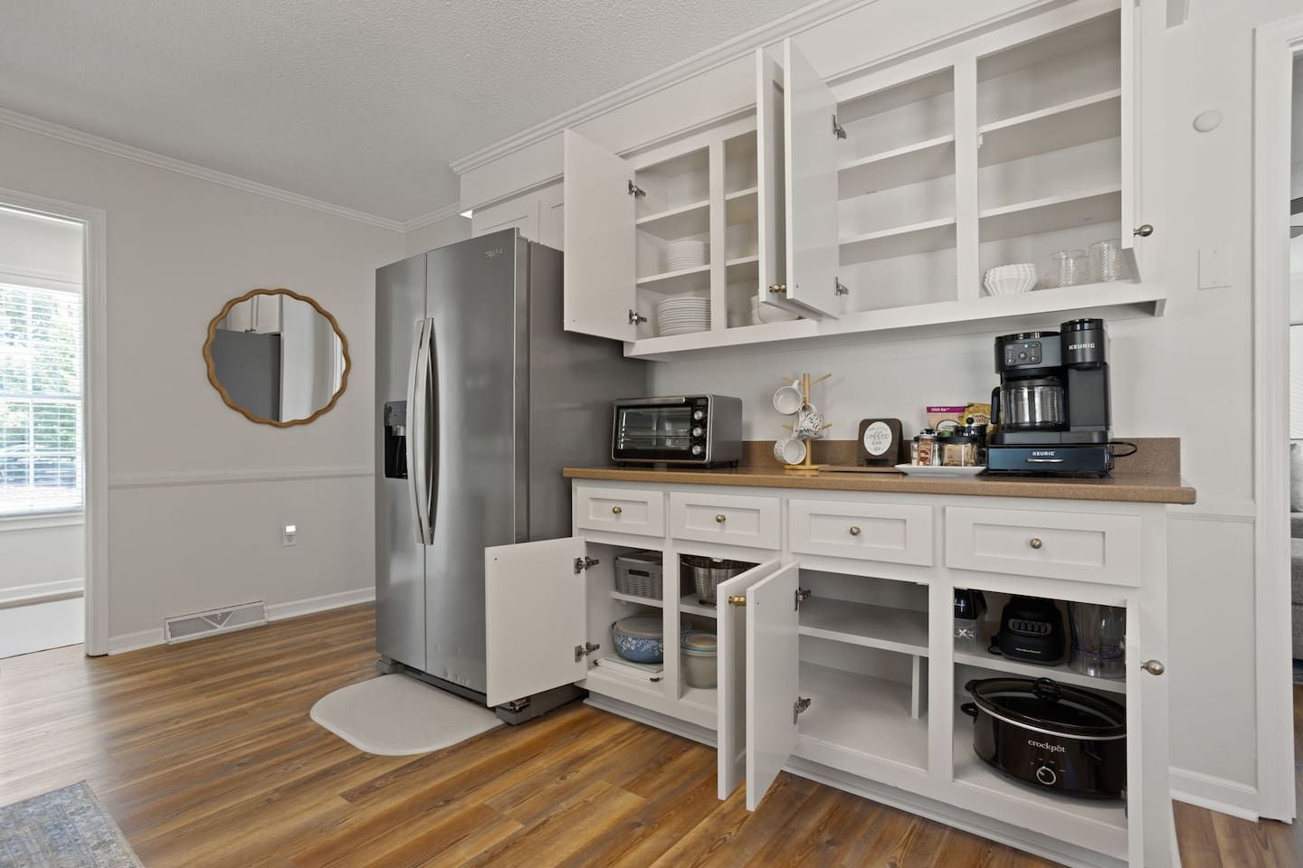 Eine moderne Küche mit integriertem Kühlschrank, Mikrowelle und Kaffeemaschine.