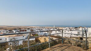 A coastal town with white buildings, a beach, and a clear sky. - Casa Mirador Information (Conil de la Frontera)