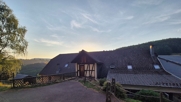 A traditional chalet with a sloped roof, a wooden deck, and a fenced driveway. - Large house with garden and terrace in Lapoutroie (Lapoutroie)