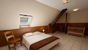 A bedroom with a bed, a chair, a crib, a window, and a staircase. - Large house with garden and terrace in Lapoutroie (Lapoutroie)