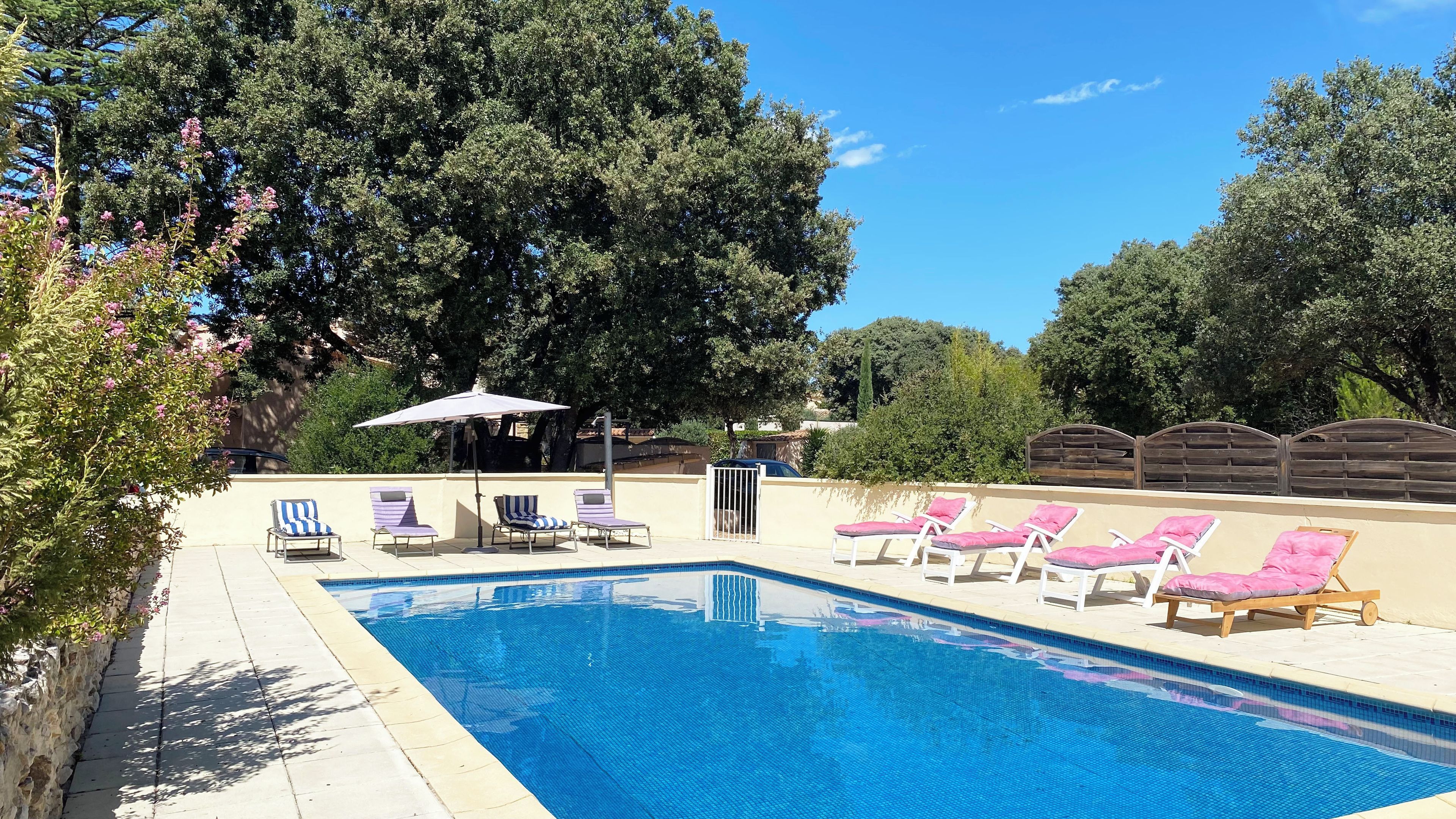 A swimming pool with lounge chairs and umbrellas.