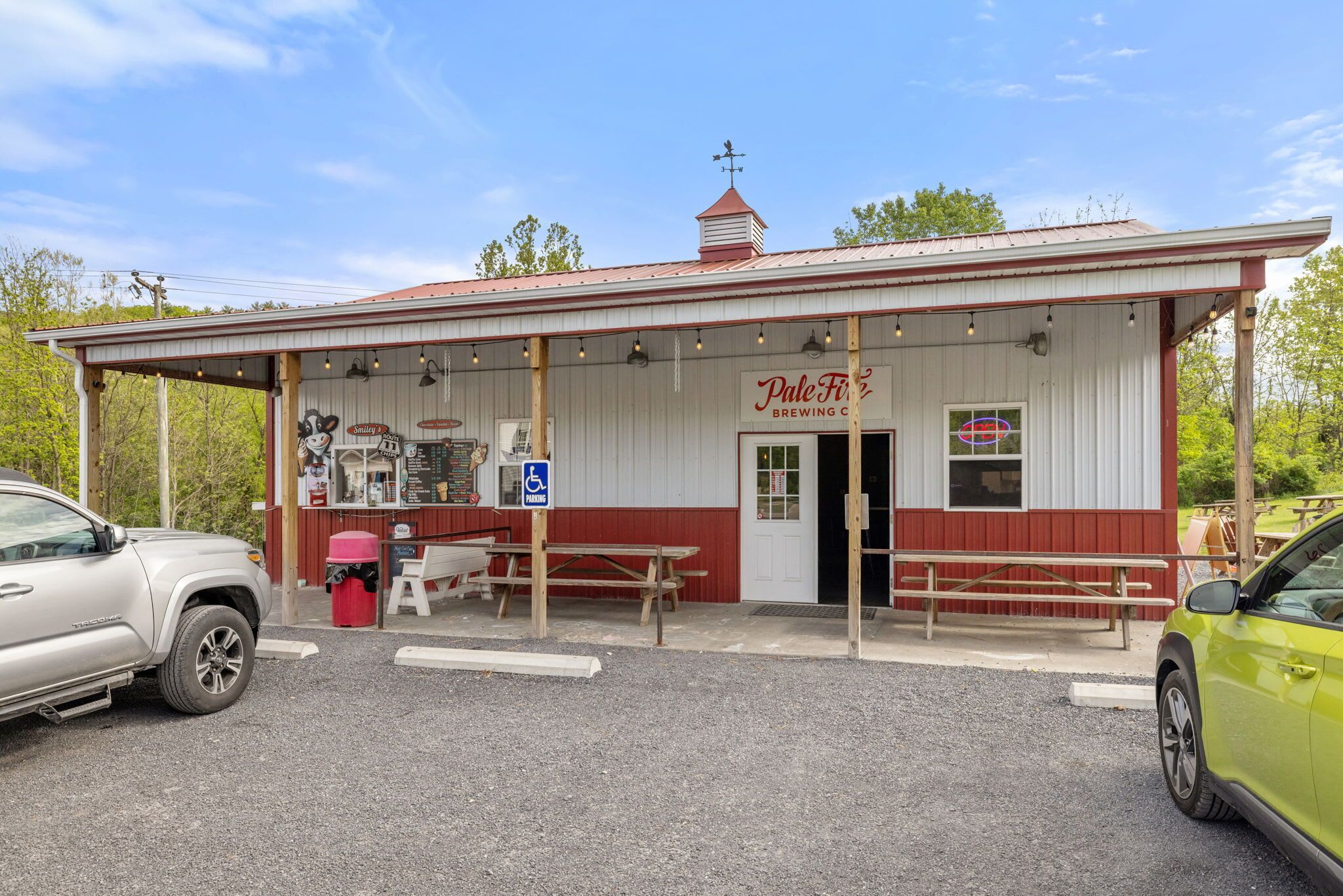 A building with a sign reading 'Pale Fire Brewing Co.' and a wheelchair-accessible parking sign.