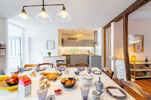 A dining area with a table set for a meal, kitchen in the background, and a sign that reads 'Cuisine'. - L'Escapade Minervoise, perfect for families or friends   (Laure-Minervois)