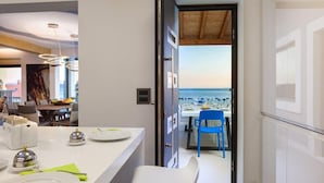 Een moderne keuken met een eethoek, uitzicht op zee en een houten plafond.