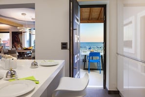 Eine moderne Küche mit Essbereich, Blick auf das Meer und Holzboden.