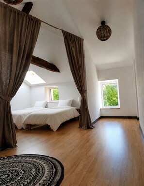 A bedroom with a bed, curtains, a skylight, a window, a round rug, and a woven light fixture. - Charming farmhouse & Open spaces (Les Cerqueux)