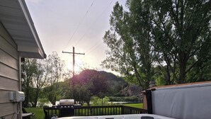 A hot tub in a backyard with a wooden deck, a grill, and a picnic table. - ~ Riverfront, Hot Tub, Mountain Views, 8 Beds ~ (Cascade)