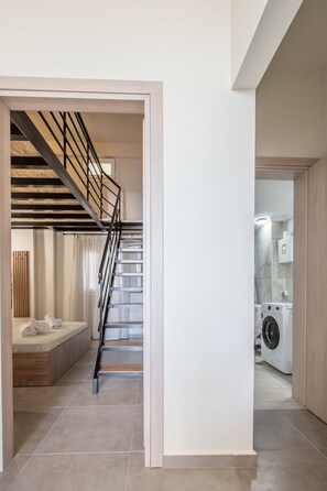 Ein modernes Interieur mit Treppe, einem Bett und einer Waschmaschine.