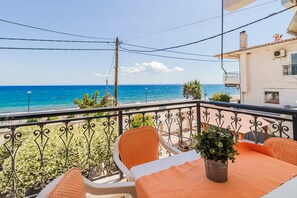 A balcony with a view of the sea, a table with chairs, and a potted plant. - 10 Steps to the beach by Rentals Pro - Kalives Halkidiki (Kalyves Polygyrou)