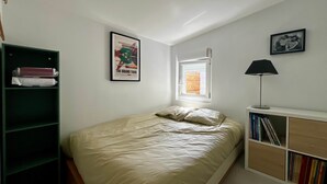 A bedroom with a bed, a window, a bookshelf, and a desk with a lamp. - BEL AIR - 3-bedroom house with a garden (Mimizan)
