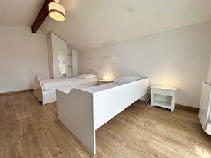 A bedroom with a bed, bedside tables, a mirror, and a ceiling light fixture. - Fronton 5 - 2-bedroom ground-floor apartment, 900 meters from the ocean (Mimizan)