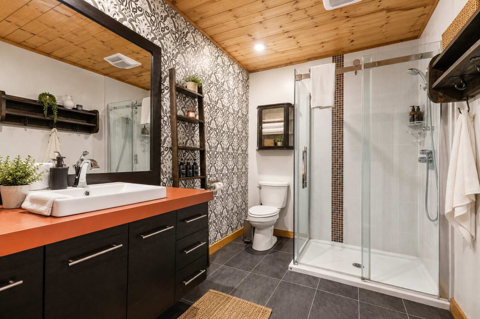 Un baño moderno con ducha, inodoro y tocador con espejo.