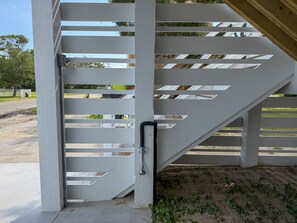 A white metal staircase with a handrail, leading to an upper level.