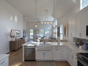 A spacious kitchen with white cabinetry, a central island, and a dining area with a sofa.