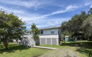A two-story house with a front porch and a small deck. - DC56: Silver Queen| Centrally Located | New Decks (Ocracoke)