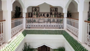 A multi-level courtyard with ornate railings, potted plants, and a checkered floor pattern. - Bab Akoul Medina & spa (Marrakech)