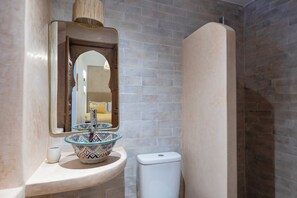 A bathroom with a sink, mirror, and toilet. - Bab Akoul Medina & spa (Marrakech)