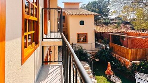 A residential building with a balcony, a small garden, and a statue. - Pousada Màe Natureza (Pirenópolis)