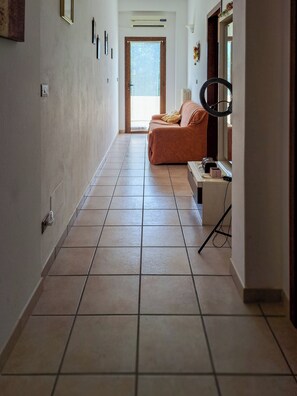 Ein Flur mit einer Couch, einem Spiegel und einem kleinen Tisch mit Gegenständen darauf.
