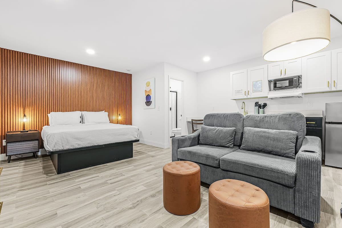 Une chambre à coucher moderne avec un lit, des tables de chevet et un mur d’accent en bois.