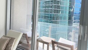 Ein modernes Zimmer mit Glastür zum Balkon, einer Couch und einem kleinen Tisch.