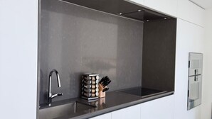 Eine moderne Küche mit Spüle, Messerblock und einem Edelstahl-Kühlschrank.