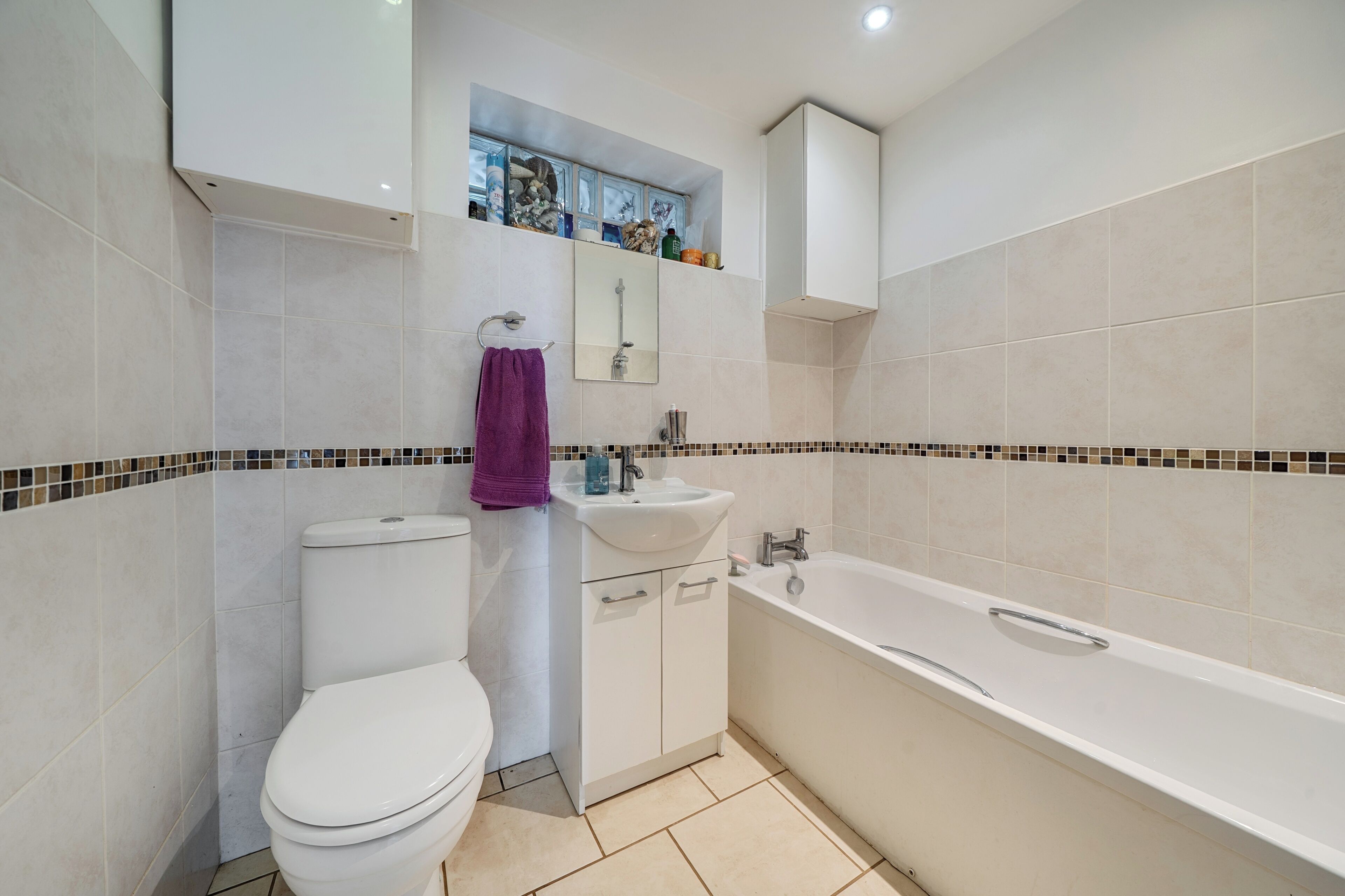 A bathroom with a toilet, sink, and bathtub.