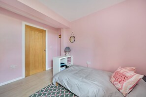 A bedroom with a bed, a nightstand, a mirror, and a wardrobe.
