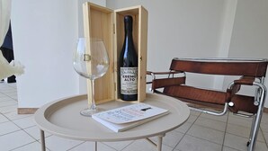 Un tavolo con una bottiglia di vino e un bicchiere, un libro e una scatola di legno.