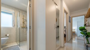 Een moderne badkamer met een douchecabine van glas, een toilet en een wastafel.