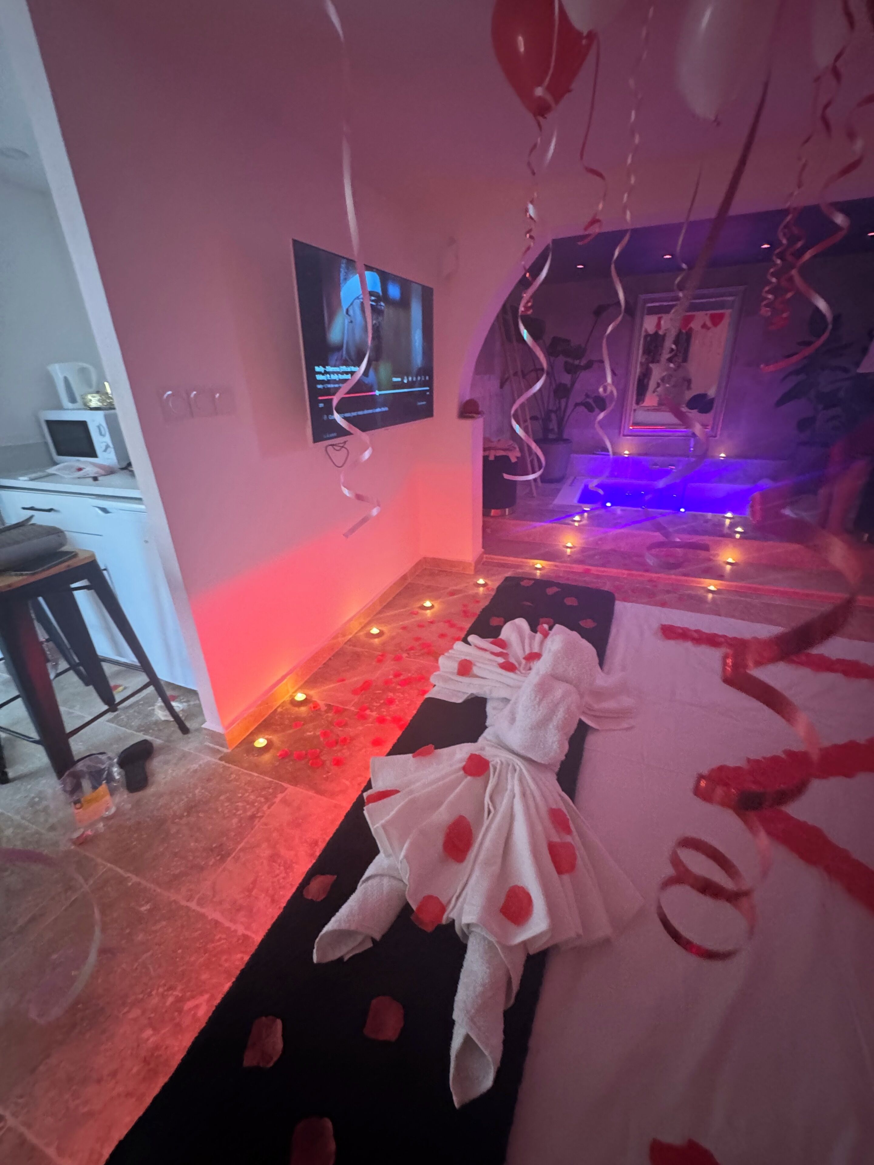 Una habitación con cama, televisión, escritorio y silla.