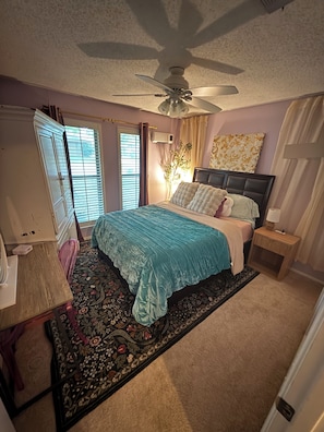A bedroom with a bed, a ceiling fan, a nightstand, a lamp, a dresser, and a window with blinds. - FIFA WORLD CUP Marvelous 2-bedroom house with Kitchenette in charming Arlington (Arlington)