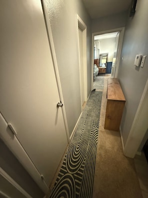 A hallway with a patterned carpet, a wooden bench, and a door leading to another room. - FIFA WORLD CUP Marvelous 2-bedroom house with Kitchenette in charming Arlington (Arlington)