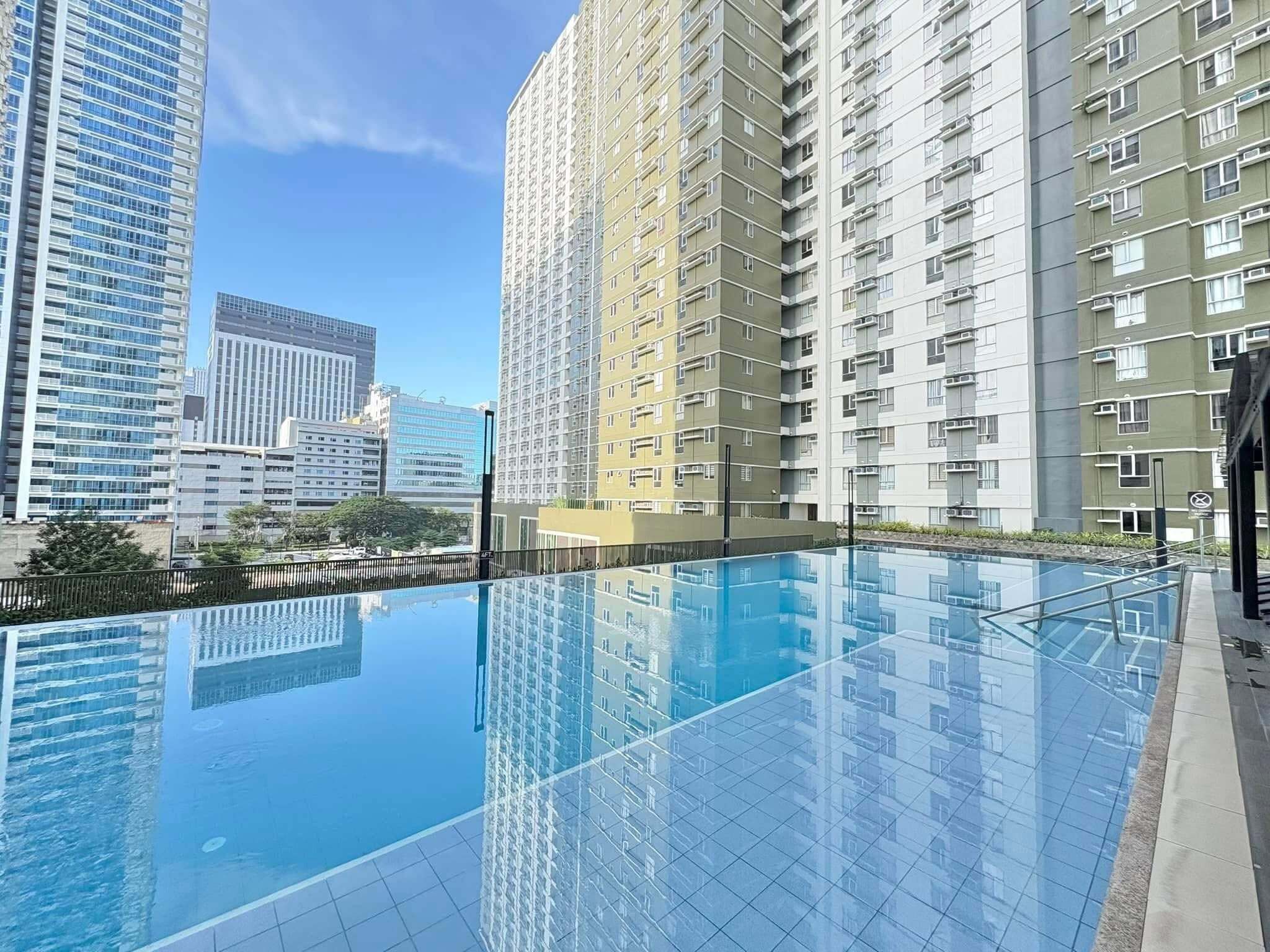A modern high-rise building with a reflective pool in the foreground.