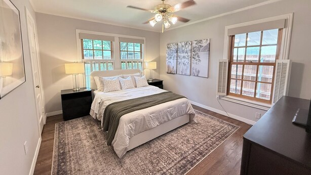 A bedroom with a bed, nightstands, a ceiling fan, and large windows. - Hilltop Hideaway Near TCU, Dickies Arena & Medical District (Fort Worth)
