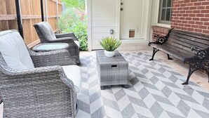 A patio with wicker furniture, a potted plant, and a bench. - Hilltop Hideaway Near TCU, Dickies Arena & Medical District (Fort Worth)