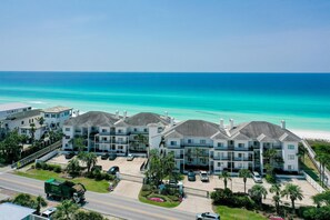 A coastal hotel with multiple-story buildings, a parking lot, and a view of the ocean. - Palms of Dune Allen 104 (Santa Rosa Beach)