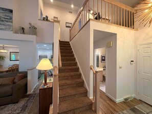Eine Treppe mit Holzwertlauf, Teppichstufen und einer weißen Tür am unteren Ende.