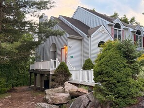 Une maison à deux étages avec un porche, une cheminée et une boîte aux lettres.
