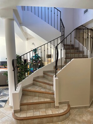 Eine Treppe mit geschwungenem Design, weißen Wänden und einem dekorativen Stern an der Wand.
