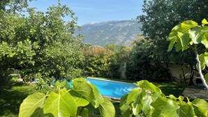 A backyard with a swimming pool, surrounded by lush greenery and mountains in the background. - Large villa at the foot of Mont Ventoux.  Ideal for families. Heated swimming pool (Mollans-sur-Ouvèze)