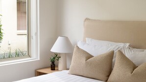 Ein Schlafzimmer mit einem Bett, einer Nachttischlampe und einem Fenster.