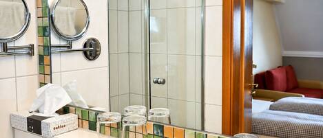 Un baño con espejo, toallero y salpicadero de azulejos.