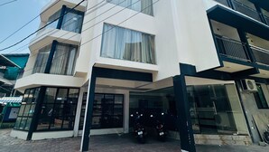 Un edificio de varias plantas con un diseño arquitectónico moderno, que destaca por sus amplios ventanales y una zona de acceso cubierta.