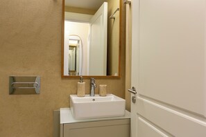 A bathroom with a white sink, a mirror, and a towel rack. - Porto Haven - Cedofeita 213 (Porto)