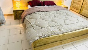 A bed with a wooden headboard, two bedside tables with lamps, and a wardrobe. - La villa bleue (M'bour)