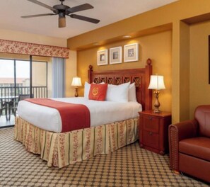 A hotel room with a bed, two bedside lamps, a wooden headboard, a balcony view, and a patterned floor. - 1 Bedroom studio AT WESTGATE LAKES RESORT & SPA NEAR DISNEY UNIVERSAL SEA WORLD. (Orlando)