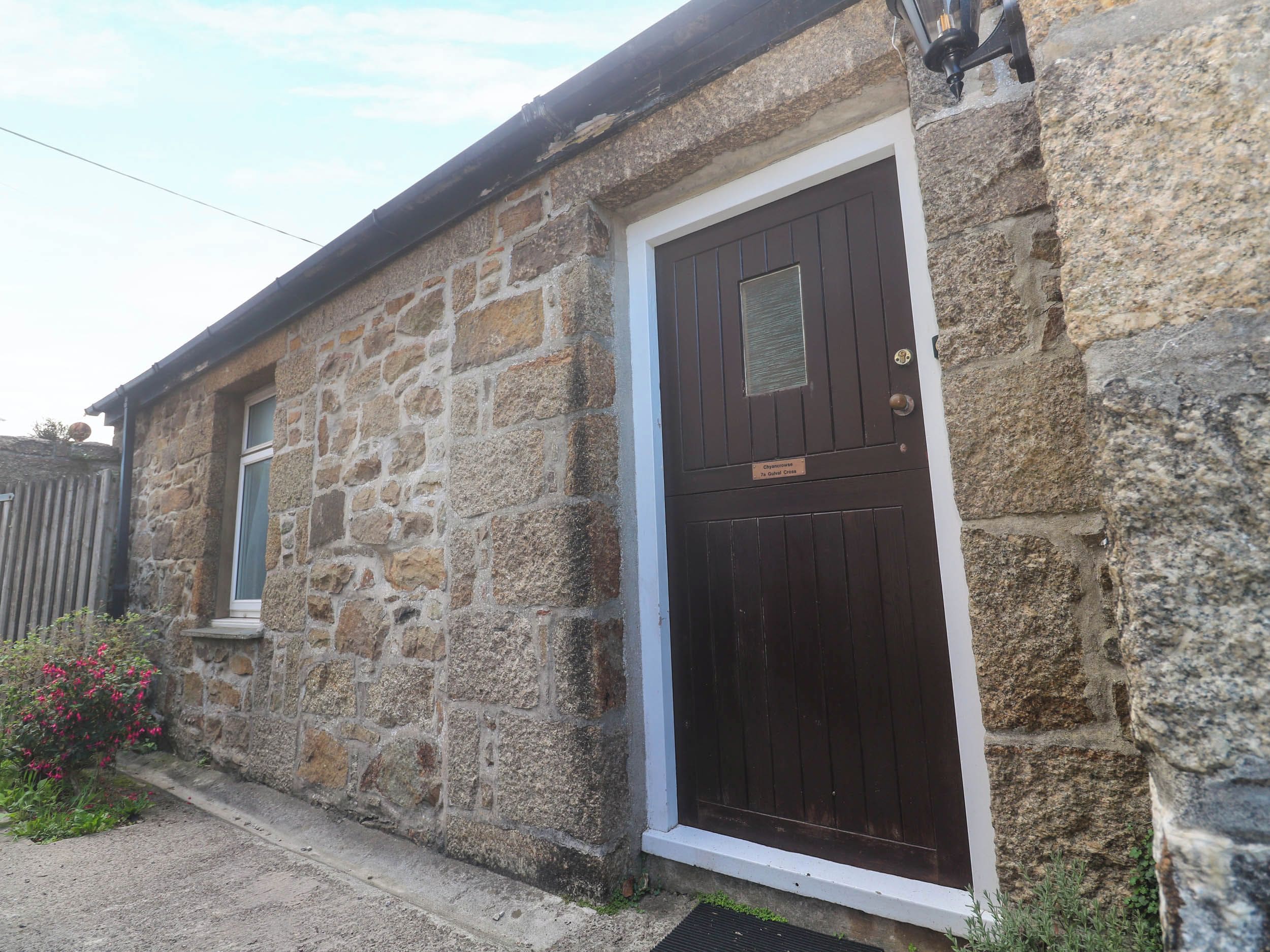 A stone building with a dark wooden door and a small window.