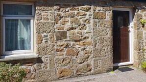 A stone house with a window, a door, and a small garden area. - Chyancrowse (Penzance)
