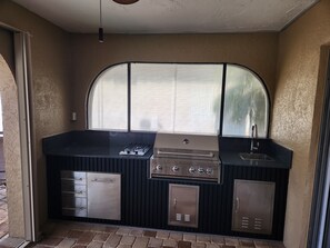 A compact kitchen with a gas stove, a sink, and storage cabinets. - Sailboat waterfront home with 60 ft dock on deep canal and heated pool (Punta Gorda)